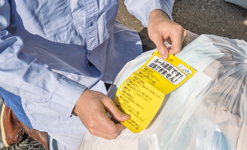 違反ゴミへのラベル貼り風景